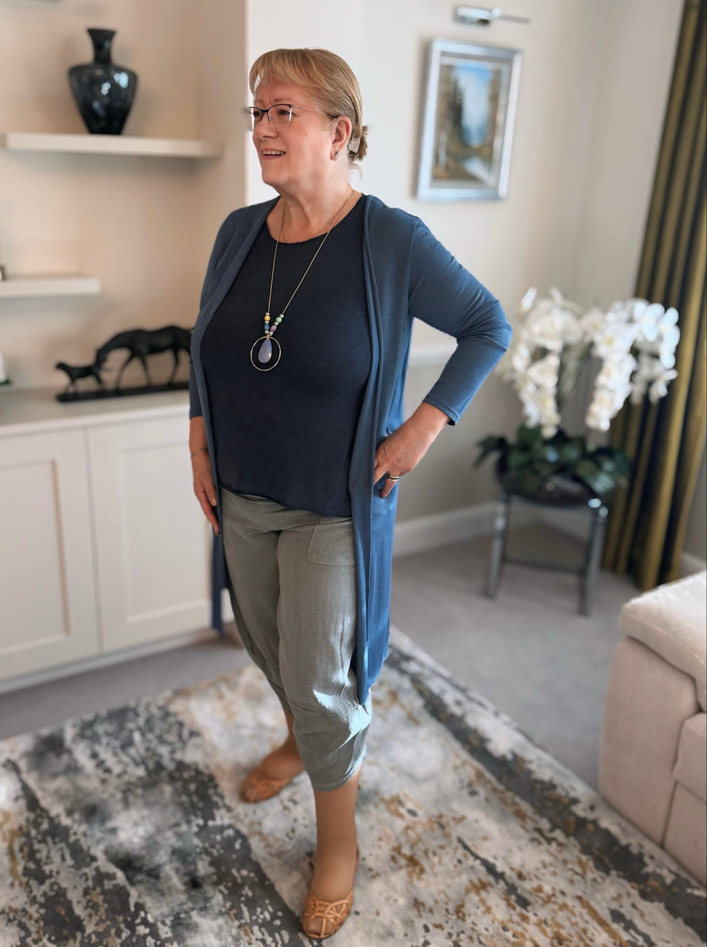 Woman wearing grey cotton harem pants and steel blue long line cardigan