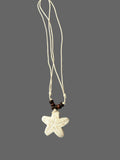 Starfish pendant necklace on a gray fabric background